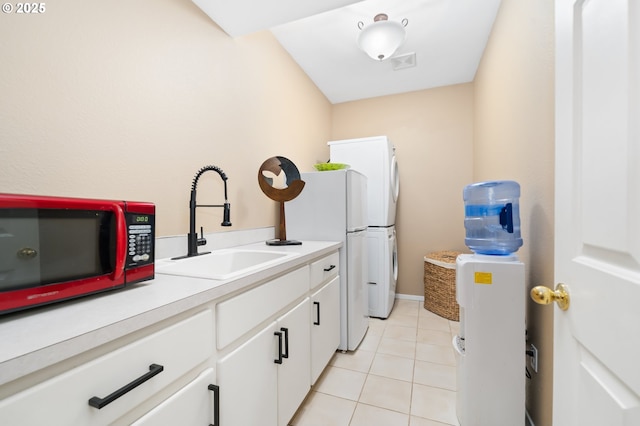 laundry room with cabinet space, light tile patterned flooring, washer / clothes dryer, and a sink