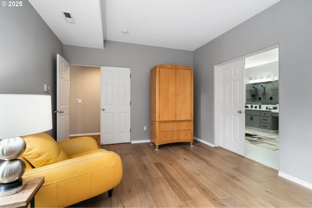 living area with visible vents, light wood-type flooring, and baseboards