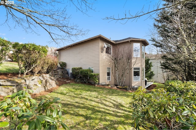 view of side of home with a yard