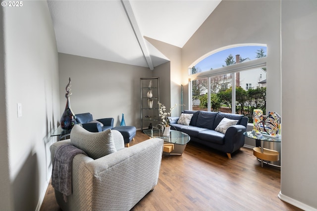 living area with wood finished floors, high vaulted ceiling, and baseboards