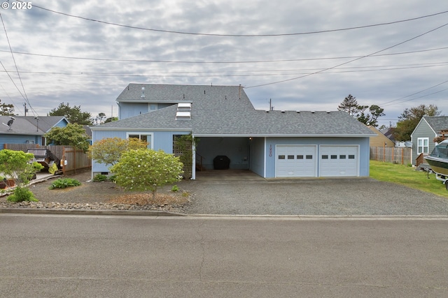 view of front of house with fence, a shingled roof, an attached garage, and driveway
