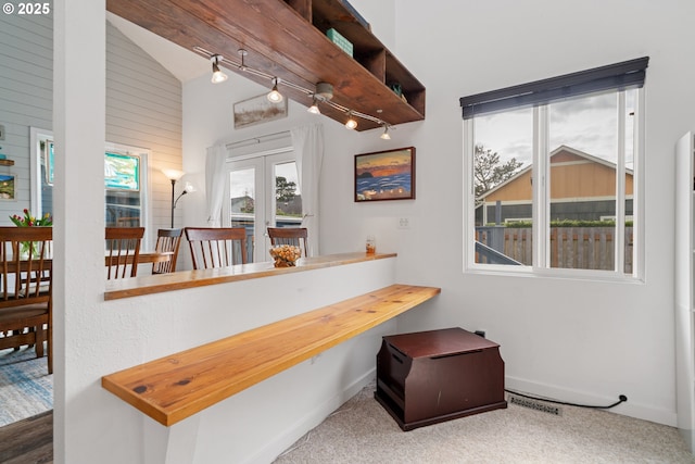 corridor with vaulted ceiling, baseboards, french doors, and visible vents