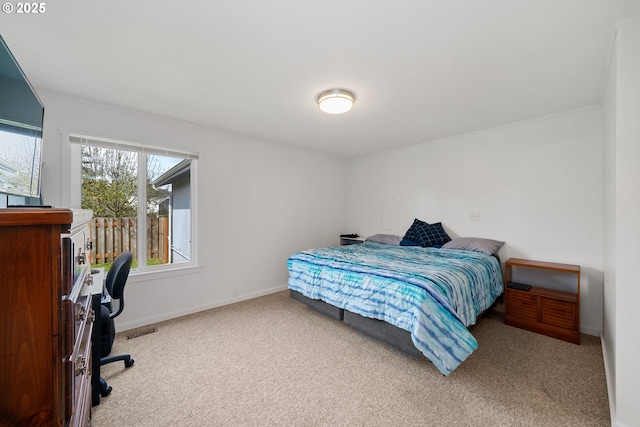carpeted bedroom with baseboards, ornamental molding, and visible vents