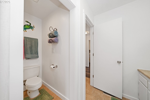 bathroom featuring toilet, baseboards, tile patterned flooring, and vanity