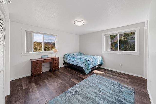 bedroom featuring visible vents, baseboards, and wood finished floors