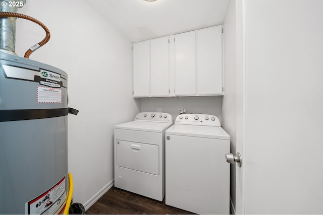 washroom with secured water heater, dark wood finished floors, cabinet space, baseboards, and separate washer and dryer