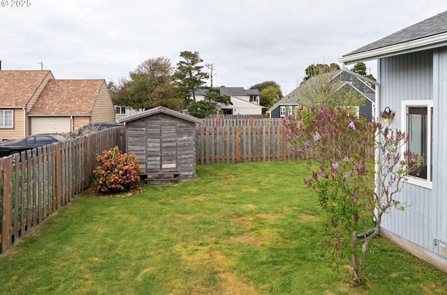 view of yard with a storage shed, a residential view, an outbuilding, and a fenced backyard