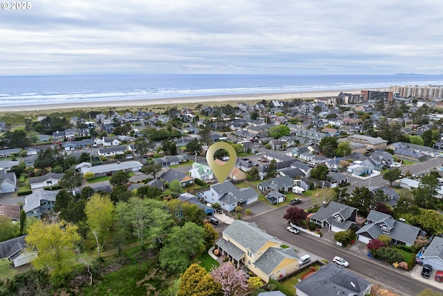 drone / aerial view featuring a water view, a residential view, and a view of the beach