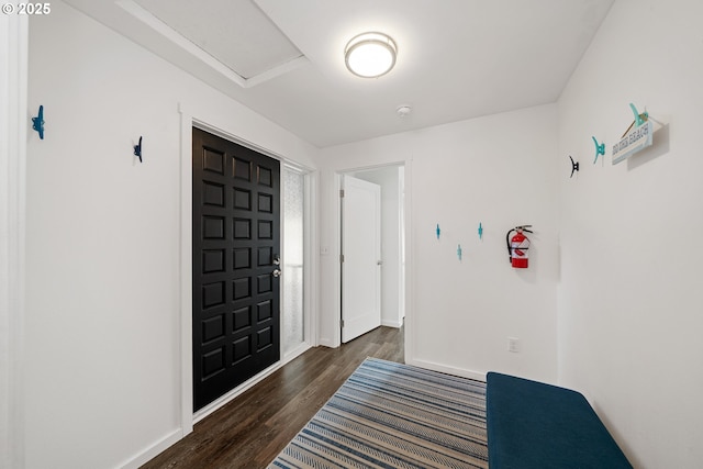 foyer featuring baseboards and wood finished floors