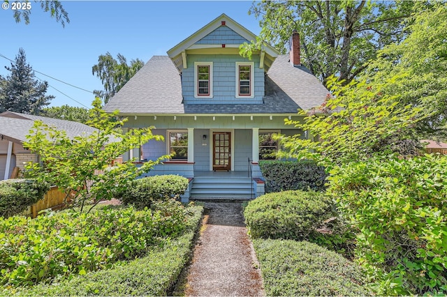1203 SE 53rd Ave, Portland, OR 97215 - bungalow featuring a shingled roof, covered porch, and a chimney