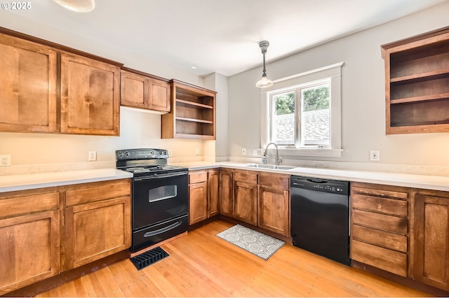 1203 SE 53rd Ave, Portland, OR 97215 - kitchen with black appliances, open shelves, light wood-style flooring, and brown cabinets