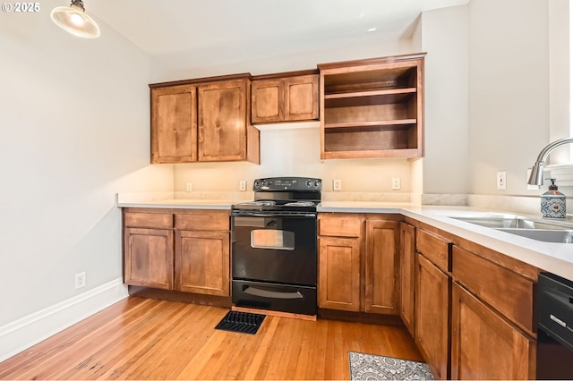 1203 SE 53rd Ave, Portland, OR 97215 - kitchen featuring black appliances, light wood-type flooring, light countertops, brown cabinetry, and open shelves