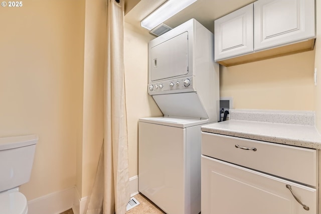 1203 SE 53rd Ave, Portland, OR 97215 - laundry room featuring stacked washer / drying machine and baseboards