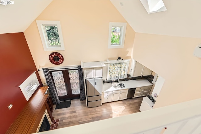 1203 SE 53rd Ave, Portland, OR 97215 - kitchen with dishwashing machine, light wood finished floors, french doors, fridge, and light countertops