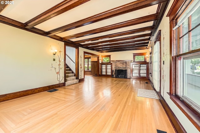 1203 SE 53rd Ave, Portland, OR 97215 - unfurnished living room with beam ceiling, a fireplace, stairs, and light wood-style floors