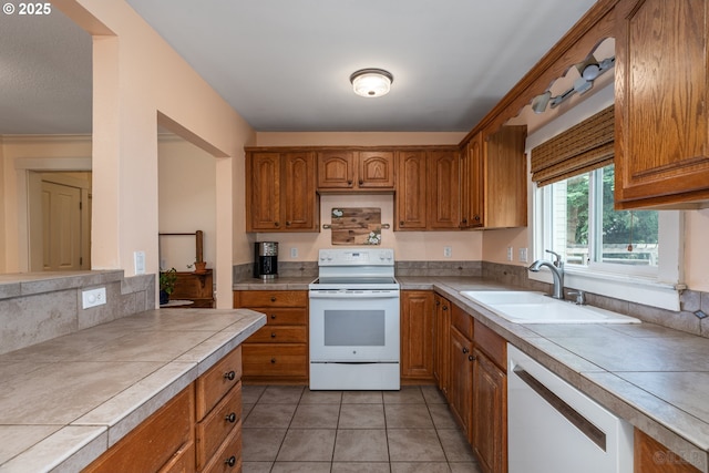 11005 SW 35th Ave, Portland, OR 97219 - kitchen featuring white appliances, tile countertops, brown cabinetry, and light tile patterned floors
