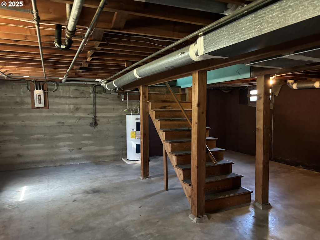 basement featuring water heater and electric panel