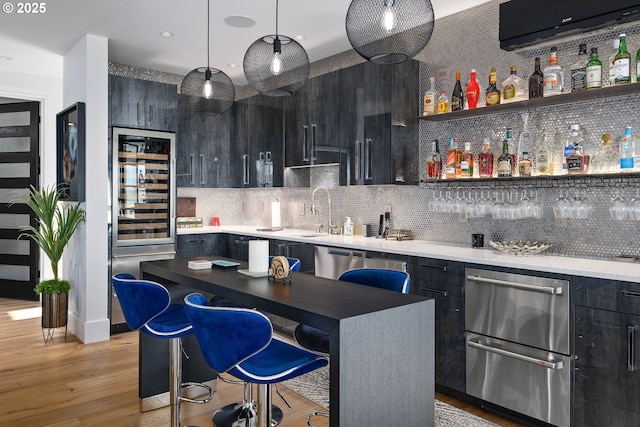 bar featuring sink, hanging light fixtures, wine cooler, tasteful backsplash, and stainless steel dishwasher