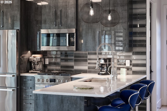 kitchen featuring tasteful backsplash, decorative light fixtures, a kitchen breakfast bar, and appliances with stainless steel finishes