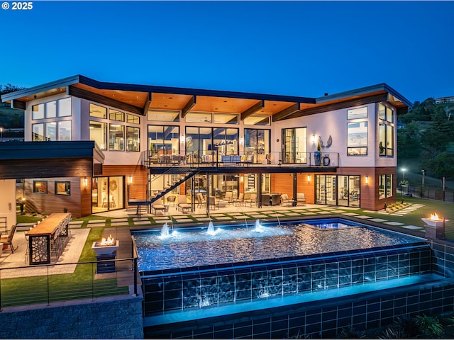 view of swimming pool featuring a hot tub, pool water feature, and a patio area