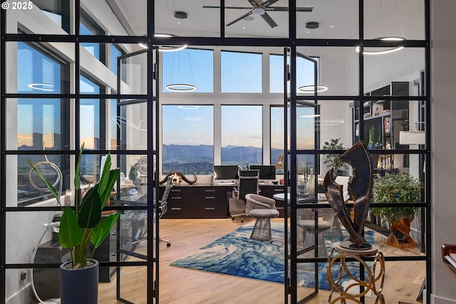 office featuring hardwood / wood-style flooring and a towering ceiling