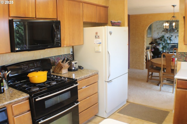 1056 NE Orchard Dr, Myrtle Creek, OR 97457 - kitchen featuring black microwave, gas range, freestanding refrigerator, a chandelier, and tasteful backsplash