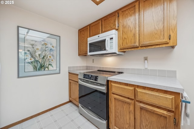 562 SW Eastman Pkwy, Gresham, OR 97080 - kitchen with stainless steel electric stove, white microwave, light countertops, light flooring, and baseboards