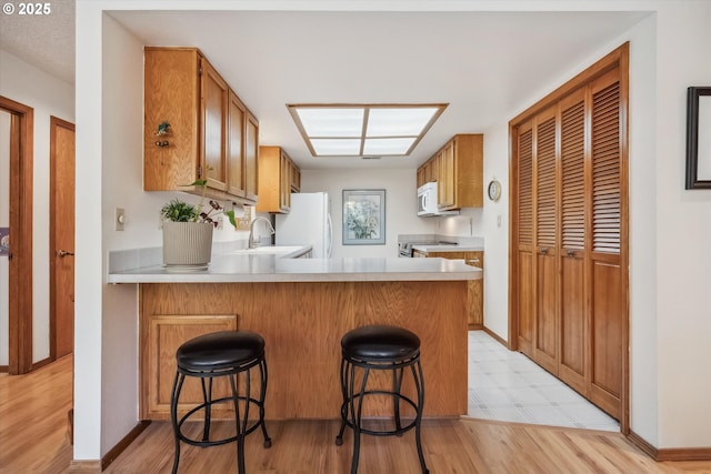 562 SW Eastman Pkwy, Gresham, OR 97080 - kitchen featuring light countertops, a sink, a peninsula, white appliances, and brown cabinets