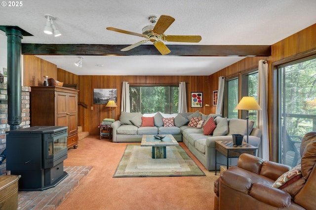 70198 E Barlow Trail Rd, Rhododendron, OR 97049 - living room with beamed ceiling, plenty of natural light, wood walls, a wood stove, and a ceiling fan