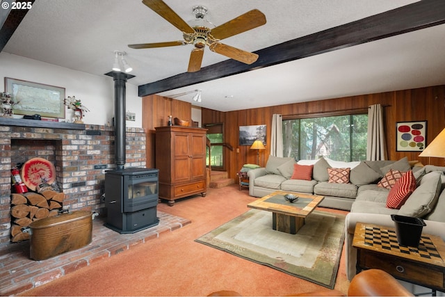 70198 E Barlow Trail Rd, Rhododendron, OR 97049 - living area featuring wooden walls, beam ceiling, a textured ceiling, light carpet, and a wood stove