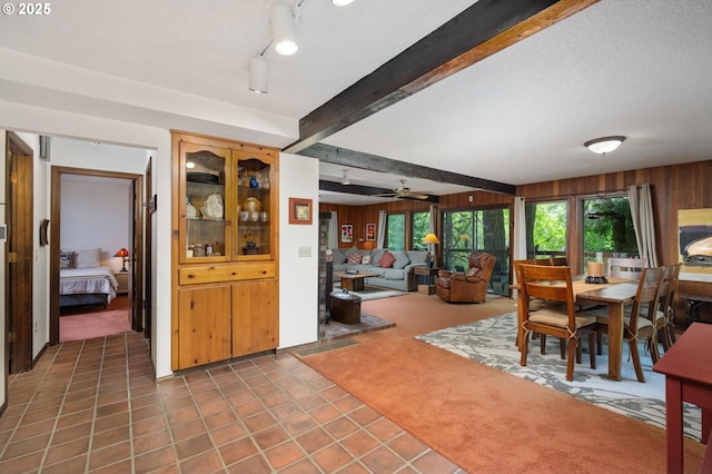 70198 E Barlow Trail Rd, Rhododendron, OR 97049 - dining space with wood walls, carpet, beam ceiling, tile patterned flooring, and a ceiling fan