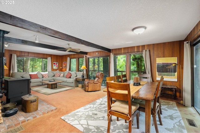 70198 E Barlow Trail Rd, Rhododendron, OR 97049 - dining area featuring light carpet, wood walls, a textured ceiling, beamed ceiling, and ceiling fan