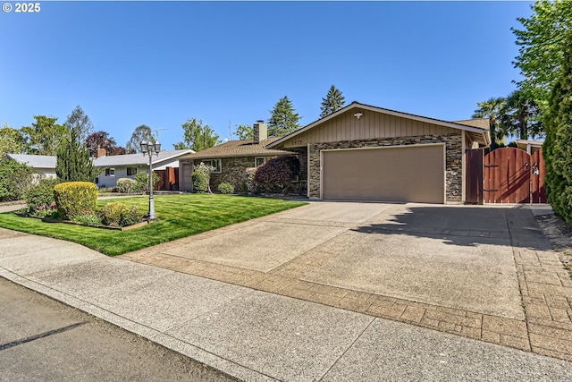 ranch-style house featuring stone siding, a garage, a front yard, a gate, and driveway