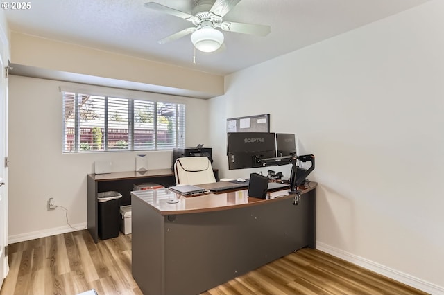 office area featuring baseboards, ceiling fan, and wood finished floors