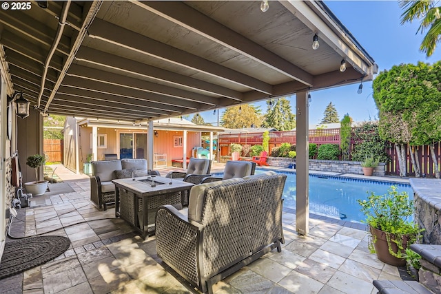 view of patio / terrace with a fenced in pool, a fenced backyard, and an outdoor living space with a fire pit