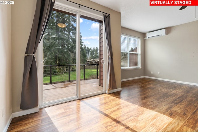entryway with ceiling fan, baseboards, a wall mounted AC, and wood finished floors