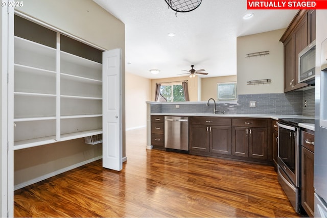 kitchen with decorative backsplash, dark brown cabinetry, ceiling fan, a sink, and appliances with stainless steel finishes