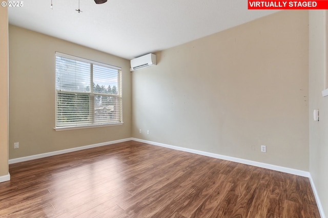 empty room with baseboards, a wall mounted AC, and wood finished floors