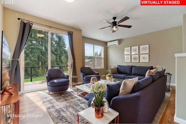 living area featuring an AC wall unit, ceiling fan, and wood finished floors