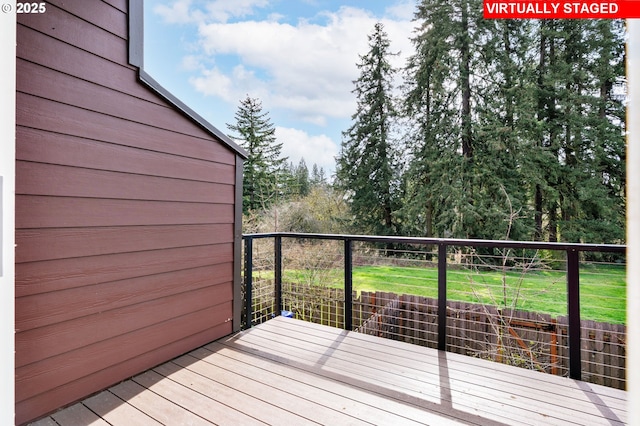wooden deck featuring a lawn