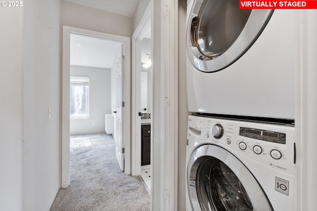 washroom with stacked washer and dryer, laundry area, and light colored carpet