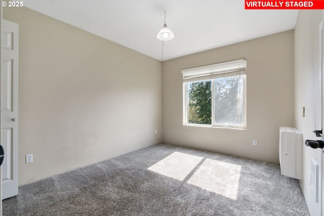 spare room with carpet and radiator