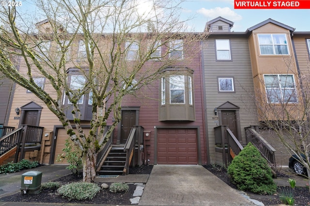 townhome / multi-family property with a garage and concrete driveway