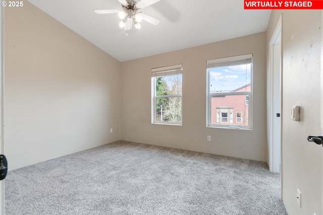 spare room with a ceiling fan, vaulted ceiling, and carpet