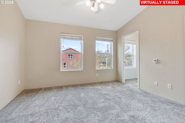 carpeted spare room with a ceiling fan and lofted ceiling