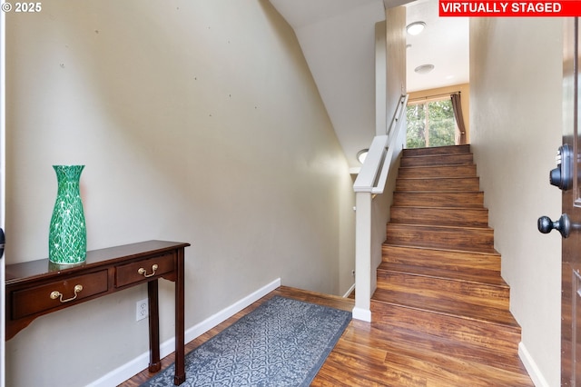 stairway featuring baseboards and wood finished floors