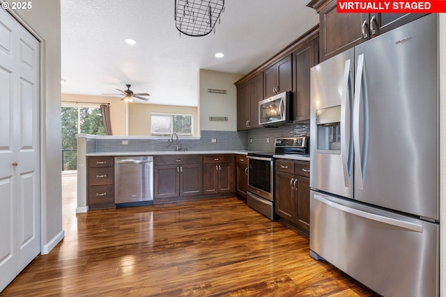 kitchen with decorative backsplash, dark brown cabinets, ceiling fan, light countertops, and stainless steel appliances
