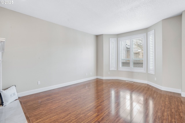 empty room featuring hardwood / wood-style flooring and a textured ceiling