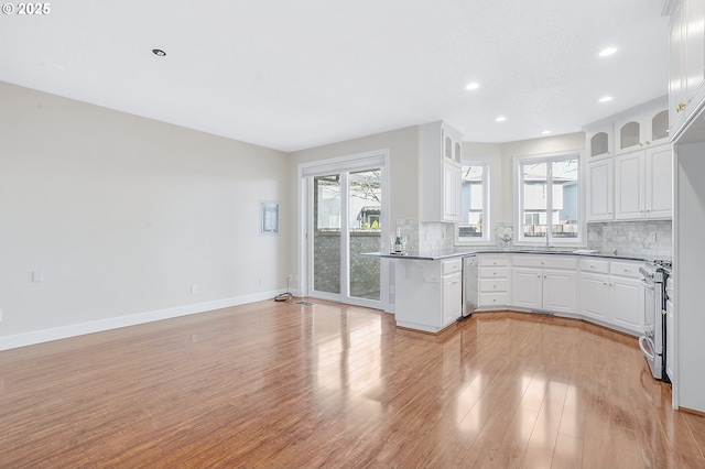 kitchen with appliances with stainless steel finishes, sink, white cabinets, and backsplash