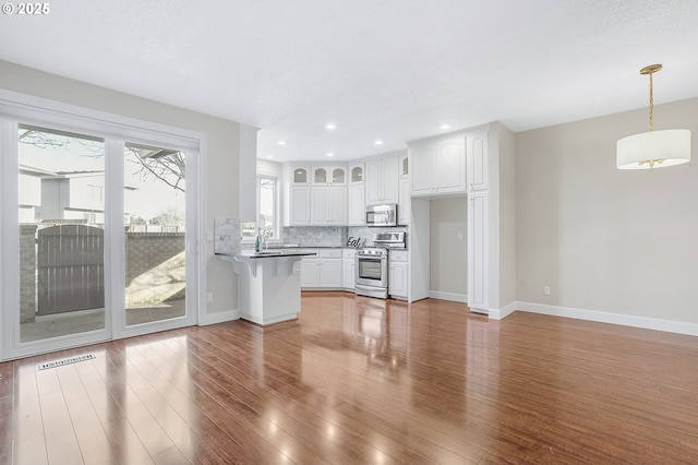 unfurnished living room with sink, a textured ceiling, and dark hardwood / wood-style flooring